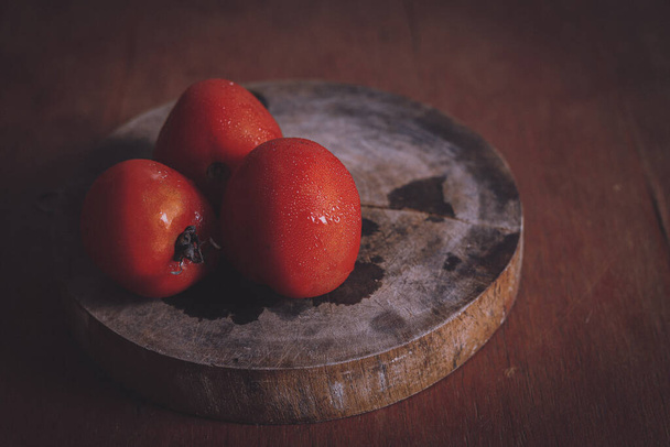 Червоні помідори, зроблені в умовах низького освітлення, щоб показати концепцію гастрономії, чистого життя та здорового харчування
 - Фото, зображення