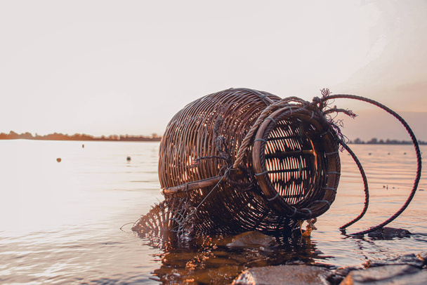 Geweven rotan creel of vismand dat is een traditionele vis container in landelijke vissersdorp in Cambodja die authentiek leven en lokale cultuur toont - Foto, afbeelding