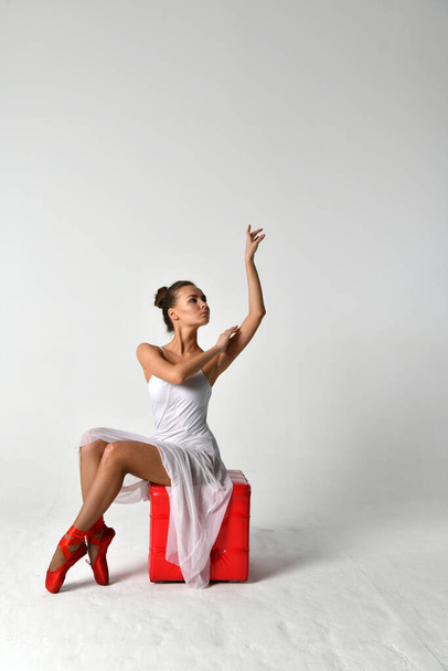 Ballerina im weißen Kleid mit roten Spitzen und rotem Würfel - Foto, Bild