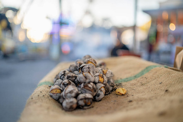 Смачні смажені каштани продаються на базарній крамниці в Фаро (Португалія).  - Фото, зображення