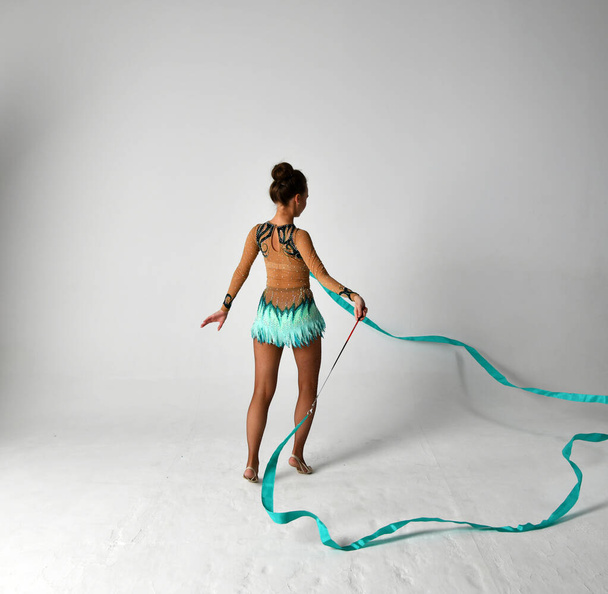 гімнастка в синьому костюмі з блакитною стрічкою танцює
 - Фото, зображення