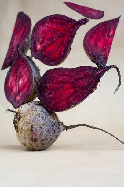 Different pieces of fresh, raw, red beet in section in unusual composition on white background. - Photo, Image