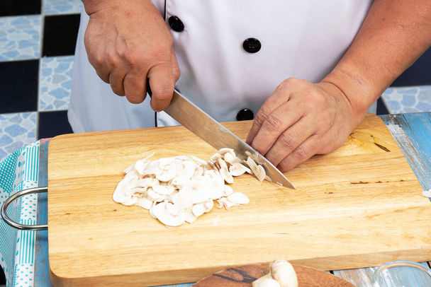 Шеф-повар вырезал грибы ножом / Концепция супа с грибным кремом
 - Фото, изображение