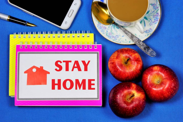 Stay at home-the text is written on a Notepad. Backed up by personal example. Convenient work from home, Internet activity on the computer and phone remotely from the office. - Photo, Image