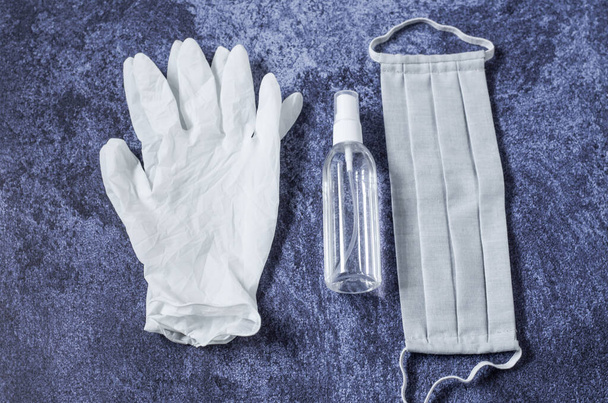 青い背景に灰色の医療用マスク、医療用手袋、防腐剤。ウイルス対策の概念。コロナウイルス対策. - 写真・画像