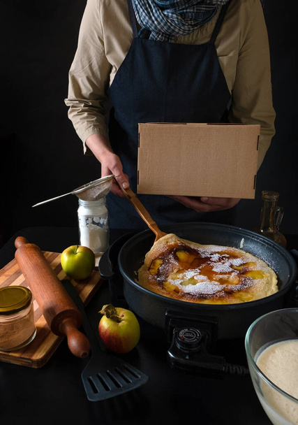 Чиф приготовления пищи на вынос, концепция службы доставки. Традиционные голландские блинчики с яблоками на сковороде
. - Фото, изображение