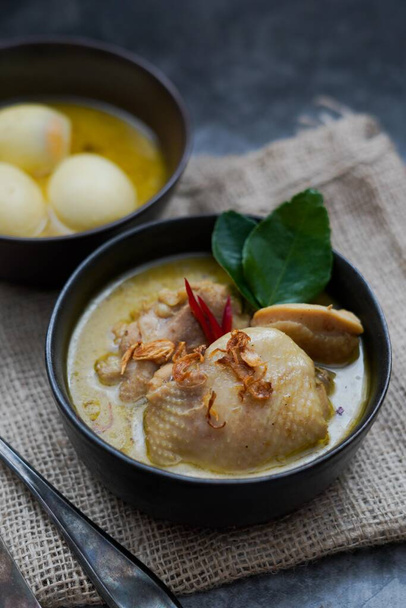 Opor Ayam (curry indonésien), poulet et œufs cuits dans du lait de coco et des épices et servis pour célébrer Idul Fitri / Lebaran avec du riz à vapeur
  - Photo, image