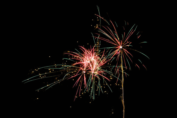 robbanó tűzijáték rakéta az újévi ünnepség ellen egy fekete éjszakai ég fénymásoló hely - Fotó, kép