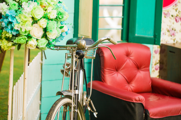 Red sofa with vintage bicycle and flower - Photo, Image