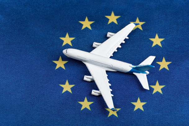 Model airplane on flag of European Union. Resumption of flights after quarantine, opening borders. - Foto, afbeelding