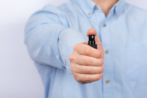 La mano dell'uomo tiene lo spray antibatterico protettivo. Vista frontale
. - Foto, immagini