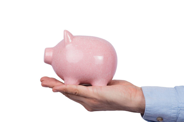 Coin Bank in hand isolated on white background. Pink pig. Side view. - Foto, immagini