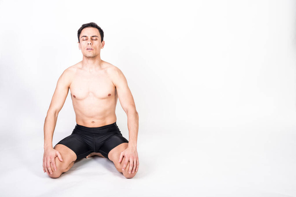 Shirtless athlete man kneeling on the floor, taking deep breaths to concentrate. Full body, white background. - Fotoğraf, Görsel