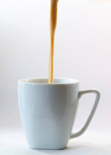filling a cup with coffee and milk - Foto, afbeelding