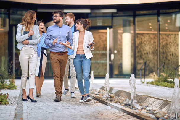 group of young businesspeople walking out of the building to have a break. leaving meeting. - Fotoğraf, Görsel