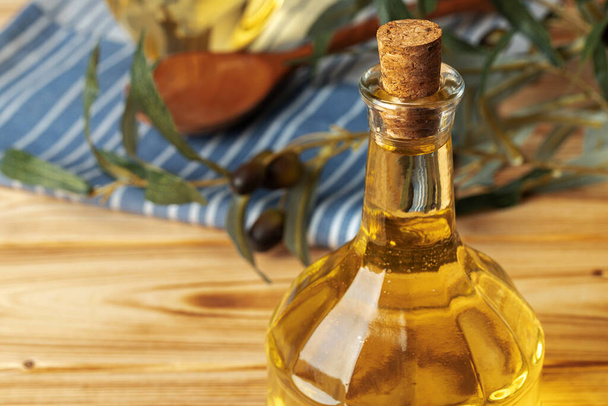 Olive oil bottle on wooden table, close up. - Fotó, kép