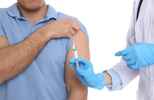 Médico inyectando al paciente sobre fondo blanco, primer plano. Concepto de vacunación
 - Foto, Imagen
