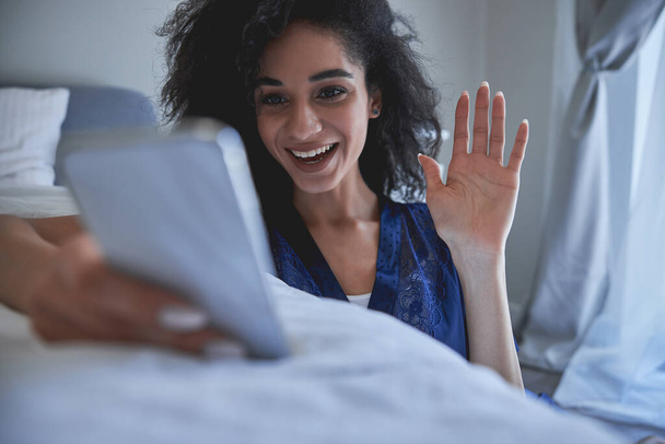 Positive delighted young brunette woman communicating online - Photo, image
