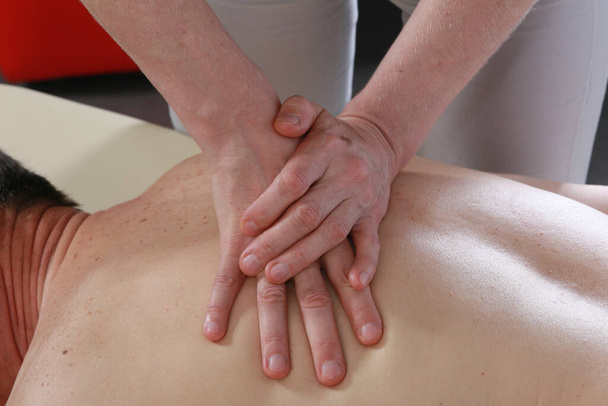 Isolated close-up of the hands of the masseur - female on man's back during a session, studio - Photo, image
