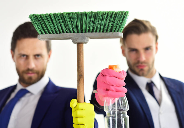 Housework, business concept. Banker and manager hold cleaning supplies. Laundering, financial crime. - 写真・画像