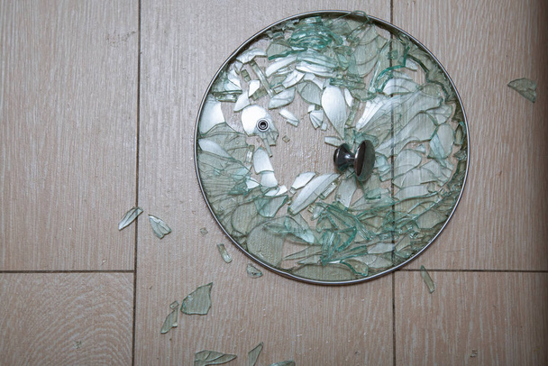 Um close-up de uma tampa de vidro quebrado encontra-se em uma estaca de azulejo. fragmentos de brilho de vidro. foco suave, vista superior
 - Foto, Imagem