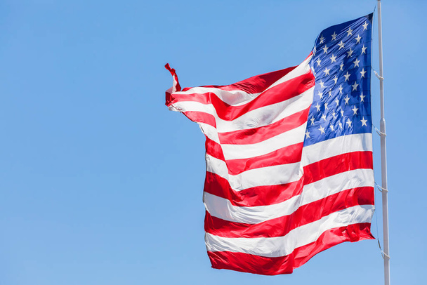 Americká vlajka vlnící se ve větru na modré obloze, pohyb pod vlajkou USA zblízka, Národní vlajka Spojených států amerických - Fotografie, Obrázek