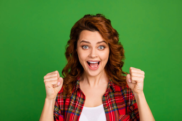 Close-up portrait of her she nice attractive amazed lucky cheerful wavy-haired girl fan wearing checked shirt holding fists having fun isolated over bright vivid shine vibrant green color background - Fotoğraf, Görsel