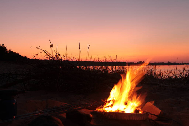 Göl kenarındaki sahil kamp ateşi. Red Superior günbatımı. Kırmızı günbatımı akşamı. Kumsalda yangın - Fotoğraf, Görsel
