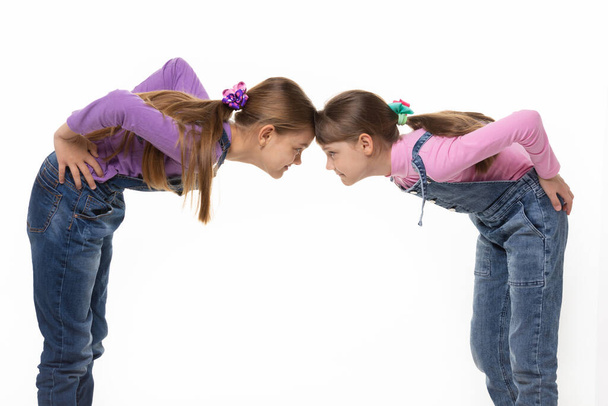 quarrel two girls standing leaning their foreheads against to each other - Fotó, kép