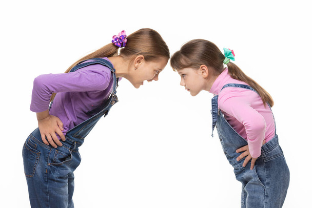 Дівчина кричить на молодшу сестру під час зміни на білому тлі
 - Фото, зображення