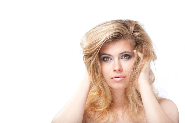 Tempting blonde young woman with large grey eyes holding hair wi - Foto, Imagen