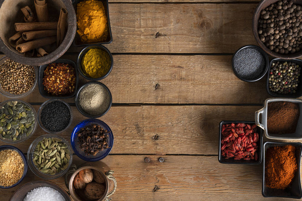 Bowls of spices across to each other on a wooden table - Photo, Image