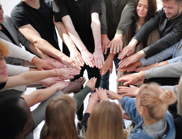 группа разных людей, объединяющих свои руки в круг. - Фото, изображение
