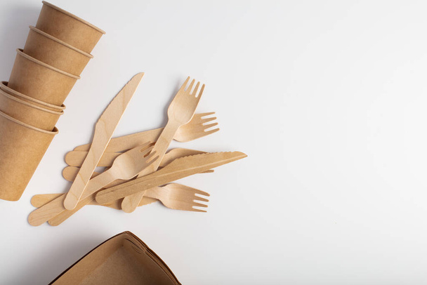 Organic dishes, the view from the top on the packaging. Wooden fork and knife, a glass. Recycling and eco-friendly disposable tableware. - Photo, Image