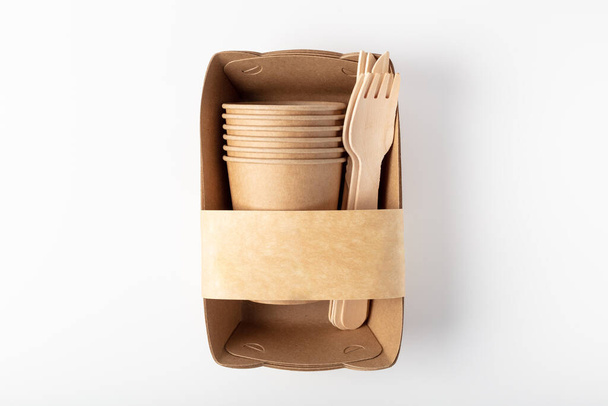 Organic eco embalagem vista superior. Recipiente, garfo, faca e xícara de madeira. Em um fundo branco
 - Foto, Imagem