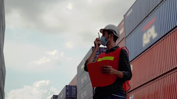 In the epidemic situation covid-19,Engineers must wear a mask while using the radio to communicate in the warehouse. Transportation industry - Footage, Video