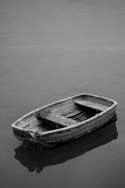 Neglected old rowing boat on calm sea water - Photo, Image