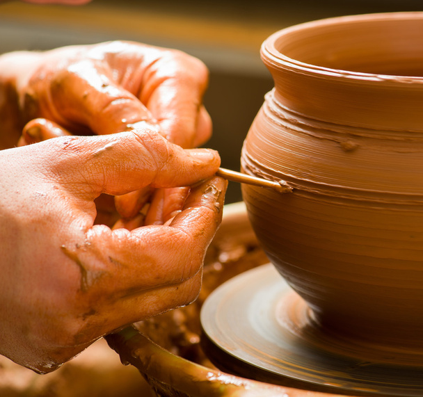 Handen van een pottenbakker, het creëren van een aarden pot op de cirkel - Foto, afbeelding