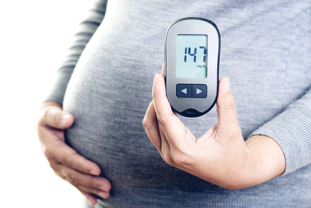 Kobiety w ciąży sprawdzają poziom cukru we krwi za pomocą miernika poziomu glukozy we krwi. Cukrzyca ciążowa. - Zdjęcie, obraz