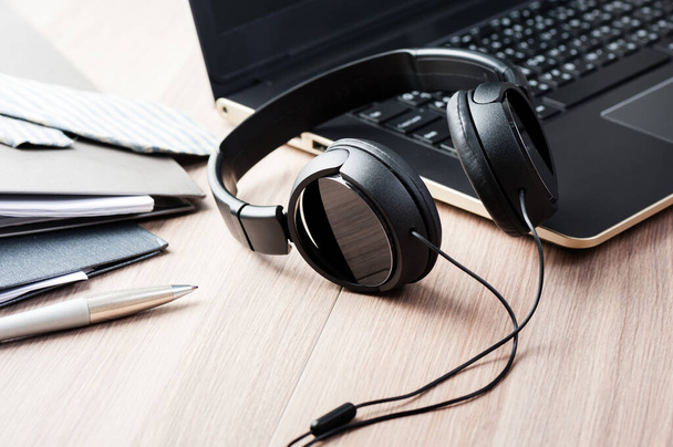 auriculares negros con cable aislados en el escritorio
 - Foto, imagen