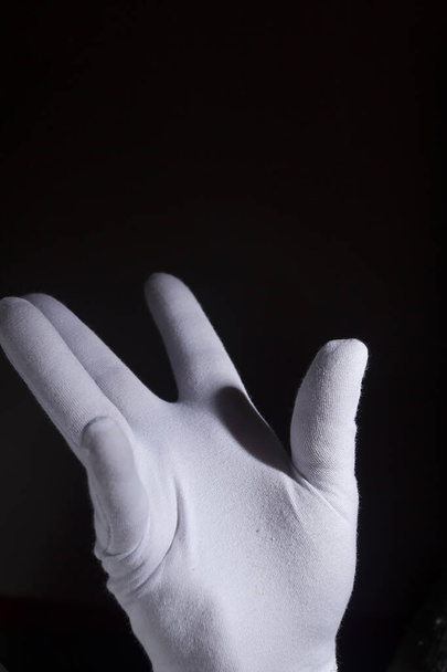 Hand in a white mime glove on a black background - Photo, Image
