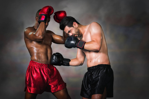 boxeador caucásico haciendo gancho a boxeador afroamericano que pierde bloque de guardia en combate de boxeo en el escenario, enfoque selectivo
 - Foto, Imagen