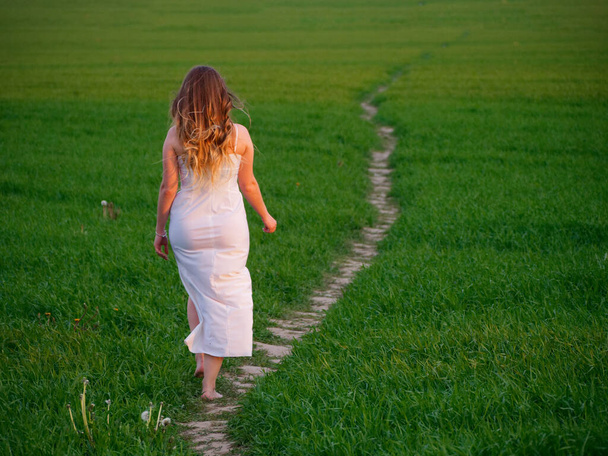 chica en un vestido blanco largo en un campo verde 2020
 - Foto, imagen
