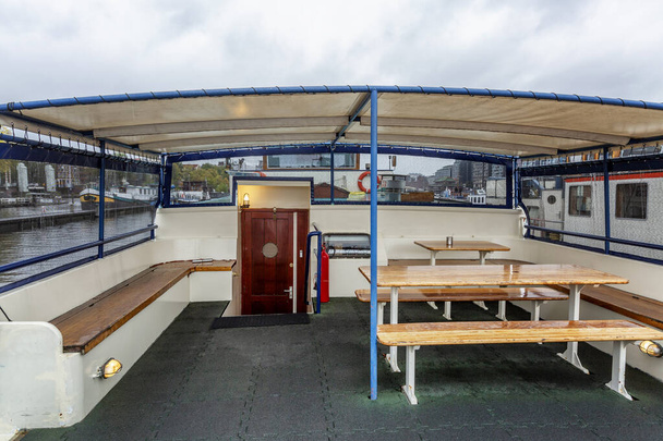 Mesas con bancos en la popa de un barco hotelero en Ámsterdam. Un lugar para relajar a los pasajeros
. - Foto, imagen