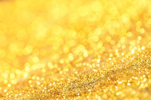 金色の輝きの質感。ぼやけたダイヤモンドの塵から輝く金の明るいボケ。抽象黄金のボケの背景。選択的集中 - 写真・画像