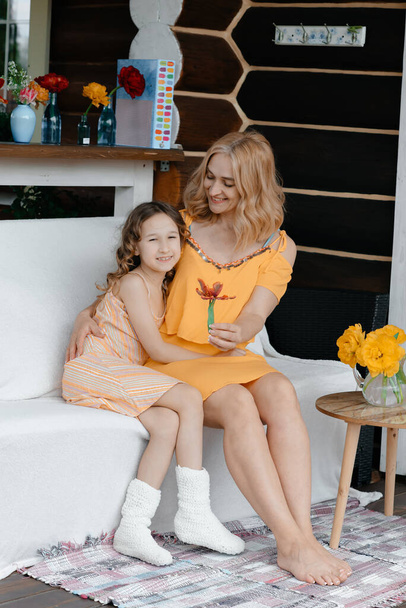 Mom and daughter at their summer house, in the summer. Lifestyle concept. Family time. - Zdjęcie, obraz