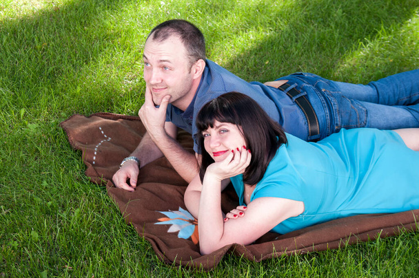 Женщина и мужчина лежат на газоне
 - Фото, изображение