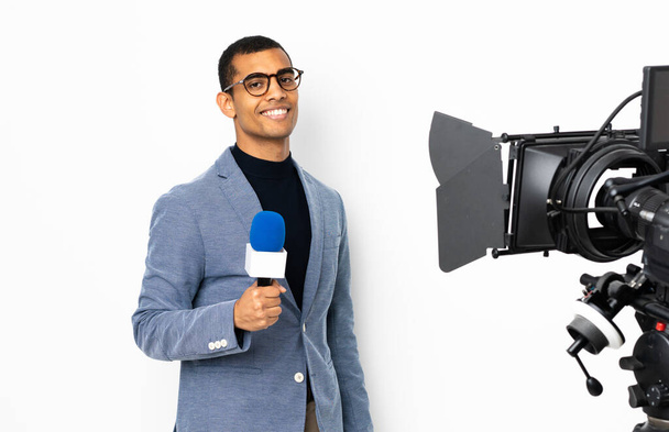 repórter afro-americano homem segurando um microfone e relatando notícias sobre fundo branco isolado - Foto, Imagem