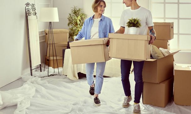 Couple holding boxes for moving the hands and looking inside box - Zdjęcie, obraz