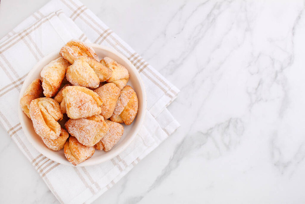 Freshly baked cottage cheese and sugar cookies (triangles, angles) in a marble background. Crow's feet. - Photo, Image